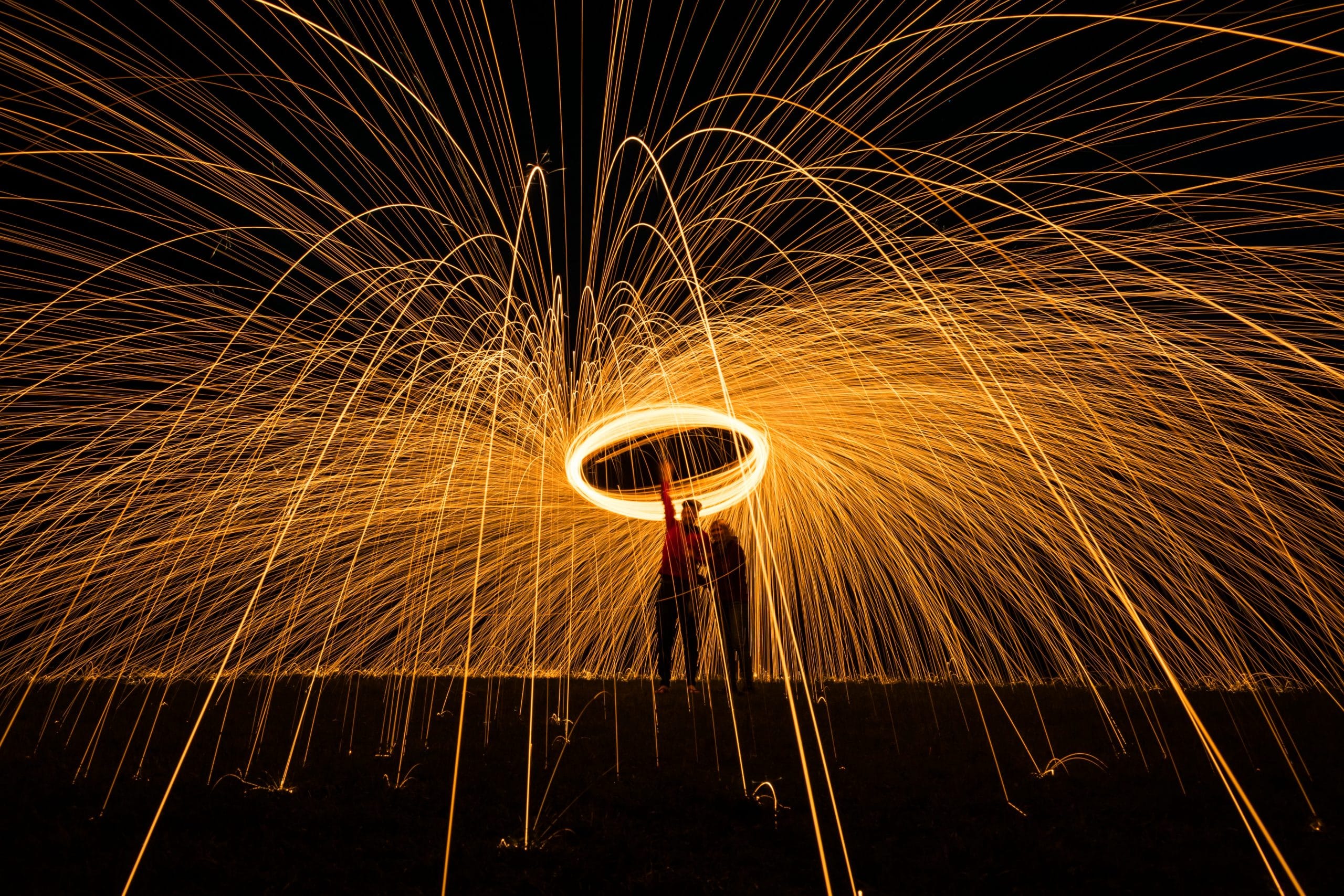 Two people holding up a large sparkler.